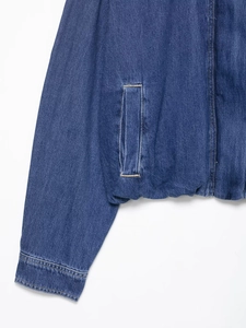 Detailed macro view of vintage blue denim jacket stitching and pocket textures