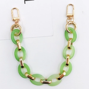 Detail of green acrylic and gold metal chain links with lobster clasps for bags