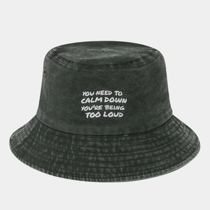 Detail of washed cotton bucket hat with white embroidery and metallic ventilation eyelets