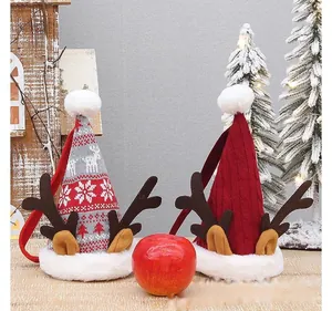 Dettaglio di sacchetti regalo di Natale per mele con corna di renna e motivi a maglia