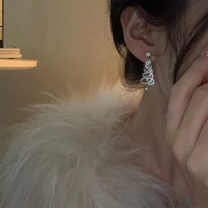 Close-up of sparkling Christmas tree drop earrings with colorful rhinestones on model