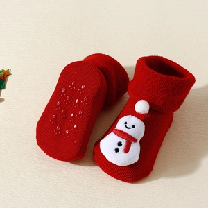 Detail of red baby Christmas socks featuring 3D snowman and anti-slip rubber soles