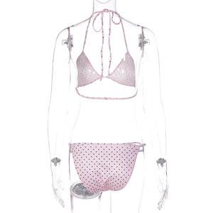 Detailed view of pink polka dot bikini top with halter neck tie on display