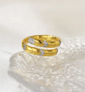 Macro shot of gold leaf ring with white zircon stones on ice texture base
