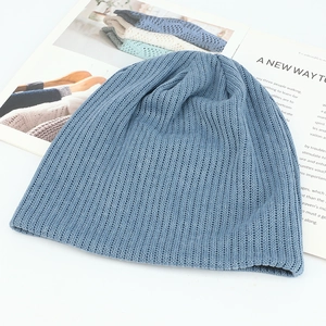 Detailed view of sky blue knit beanie texture with vertical rib stitch on white surface