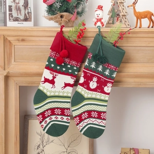 Knitted Christmas stockings with reindeer and snowman patterns on a festive mantelpiece
