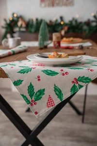 Detail of Christmas holly leaf print placemat made of textured beige cotton linen fabric