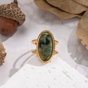 Detailed view of vintage gold ring with oval turquoise stone on white stone block