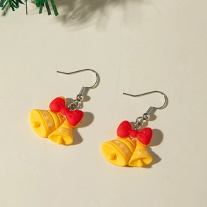 Vue détaillée de boucles d'oreilles cloches de Noël jaunes avec nœuds rouges et étoiles