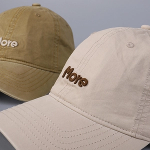 Close-up of premium More 3D embroidery on washed cotton baseball caps with fine stitching