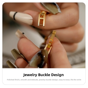 Macro detail of the polished gold metal jewelry clasp on a lady's minimalist steel watch