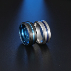Detail of matte black and brushed silver stainless steel rings with blue inner bands