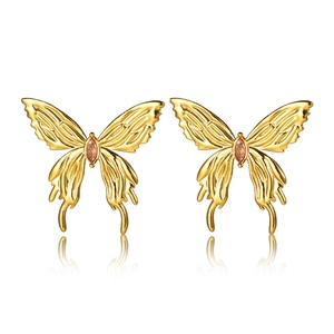 Detail view of gold-plated butterfly earrings with pink gemstones on white background