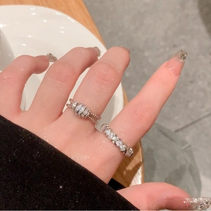 Close-up of minimalist geometric rings with zircon inlay on a person finger