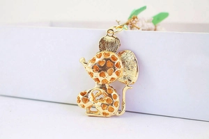 Detailed close-up of a golden metal mouse pendant with hollow heart patterns for keychains