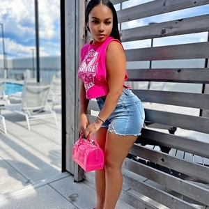 Top senza maniche vintage rosa da donna abbinato a pantaloncini di jeans blu chiaro
