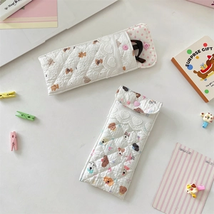 Quilted cotton padded eyewear pouches with cute cartoon dog and bear prints in desk setting