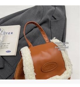 Close-up of brown faux leather backpack with white plush trim and embossed fashion logo