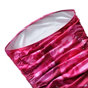 Detailed view of elastic pleated neckline and pink floral print fabric with silver dots