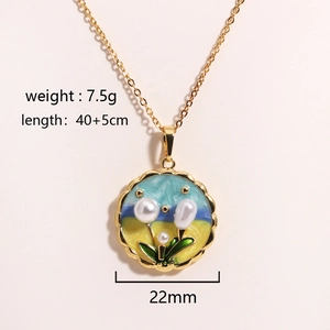 Flat lay of gold necklace with blue-yellow enamel flower pendant and three pearls