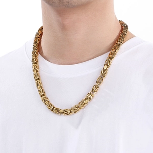 Close-up of men's gold plated stainless steel square link chain necklace worn on a white t-shirt