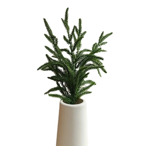 Realistic Norfolk pine needle branches in a white ceramic vase for Christmas home decor