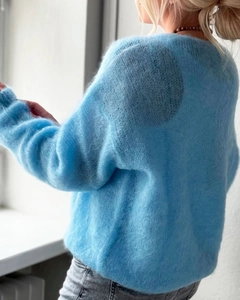 Detailed texture of light blue soft v-neck knit sweater with fluffy mohair fibers