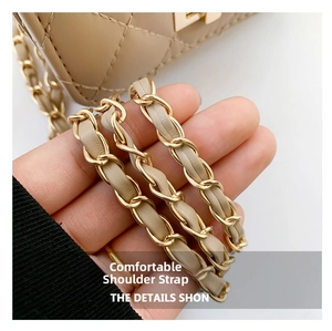 Detail of beige quilted leather shoulder bag featuring a classic gold chain strap