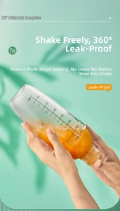 Detailed view of clear shaker with 700cc scale and orange juice with ice cubes