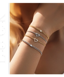 Close-up of stacked S925 silver and gold bracelets with heart and round Moissanite charms