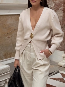Dettaglio cardigan in maglia a coste beige con profondo scollo a V e bottone dorato