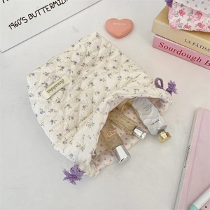 Quilted floral toiletry bag with purple tassel drawstring showing inner storage space