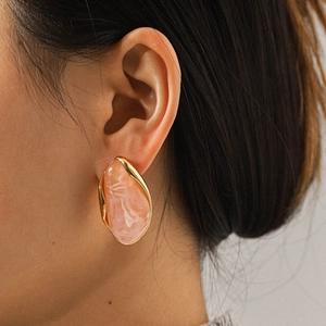 Close-up of model wearing pink marble resin earrings with vintage gold stainless steel frame