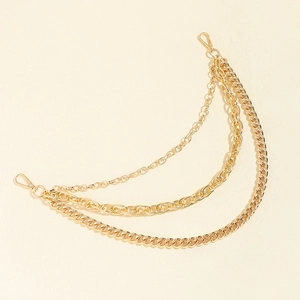 Detailed macro view of triple-layered golden metal chains with curb and oval links