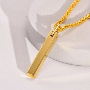 Macro shot of gold geometric bar pendant necklace on a textured stone base