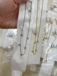 Close-up of titanium steel cherry pendant necklaces in gold and silver finishes
