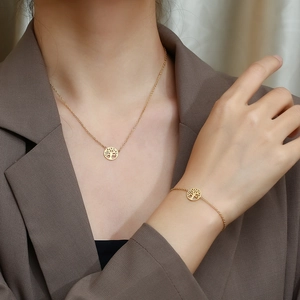 Golden Tree of Life stainless steel necklace and bracelet set worn by a female model