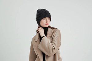 Close-up of a black knit beanie showing the thick premium wool texture and ribbed cuff