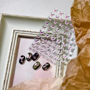 Detail view of 3D butterfly nail stickers with silver edges on various base colors