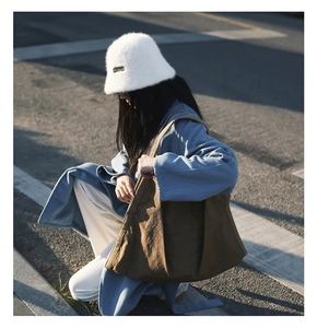 Detailed view of a brown nylon tote bag with a minimalist pleated design for women
