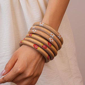 Detail of seven handcrafted wooden bangles featuring hand-painted floral and strawberry patterns