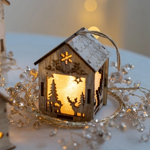 Lighted wooden Christmas house ornament with reindeer silhouette and warm LED glow