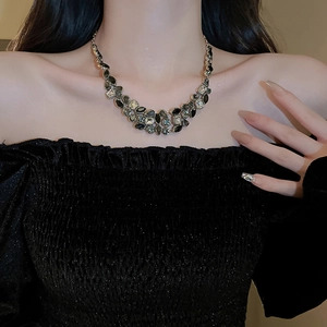Close-up of sparkling rhinestone waterdrop tassel necklace on a model's neckline