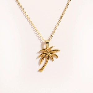 Detailed close-up of a golden coconut tree pendant necklace on a clean white background