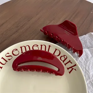 Detailed close-up of large deep red acetate hair claws with premium glossy handmade finish