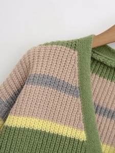 Close-up of waffle-knit cardigan with colorful stripes on a wooden hanger display