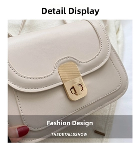 Detail of the golden twist lock with vertical textures on a beige leather crossbody bag