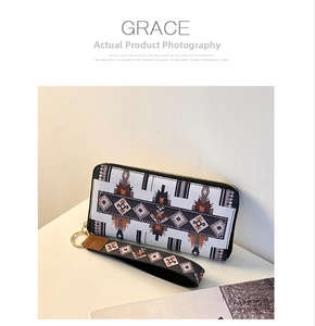 Detail of long zip wallet with geometric ethnic pattern and detachable wrist strap