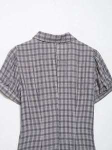 Detail of grey and white plaid fabric texture with collar and back stitching design