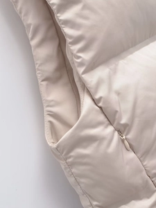 Detailed close-up of apricot quilted vest with seamless zipper and precise stitching